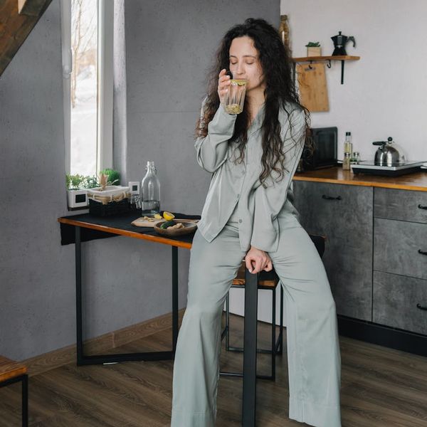 Woman smiling serenely with her eyes closed, feeling energized and at peace after a yoga session.